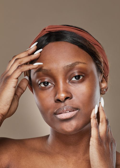 Vertical portrait of young African-American woman looking at camera with no makeup, real beauty concept